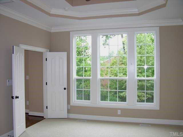 3903 Morvan Way Raleigh, NC 27612 - Photo 5 of 12 One of 2 master bedrooms. This one is on the 1st floor. Boosts deep trey ceiling, crown molding and view of hardwood trees. Master Bedroom