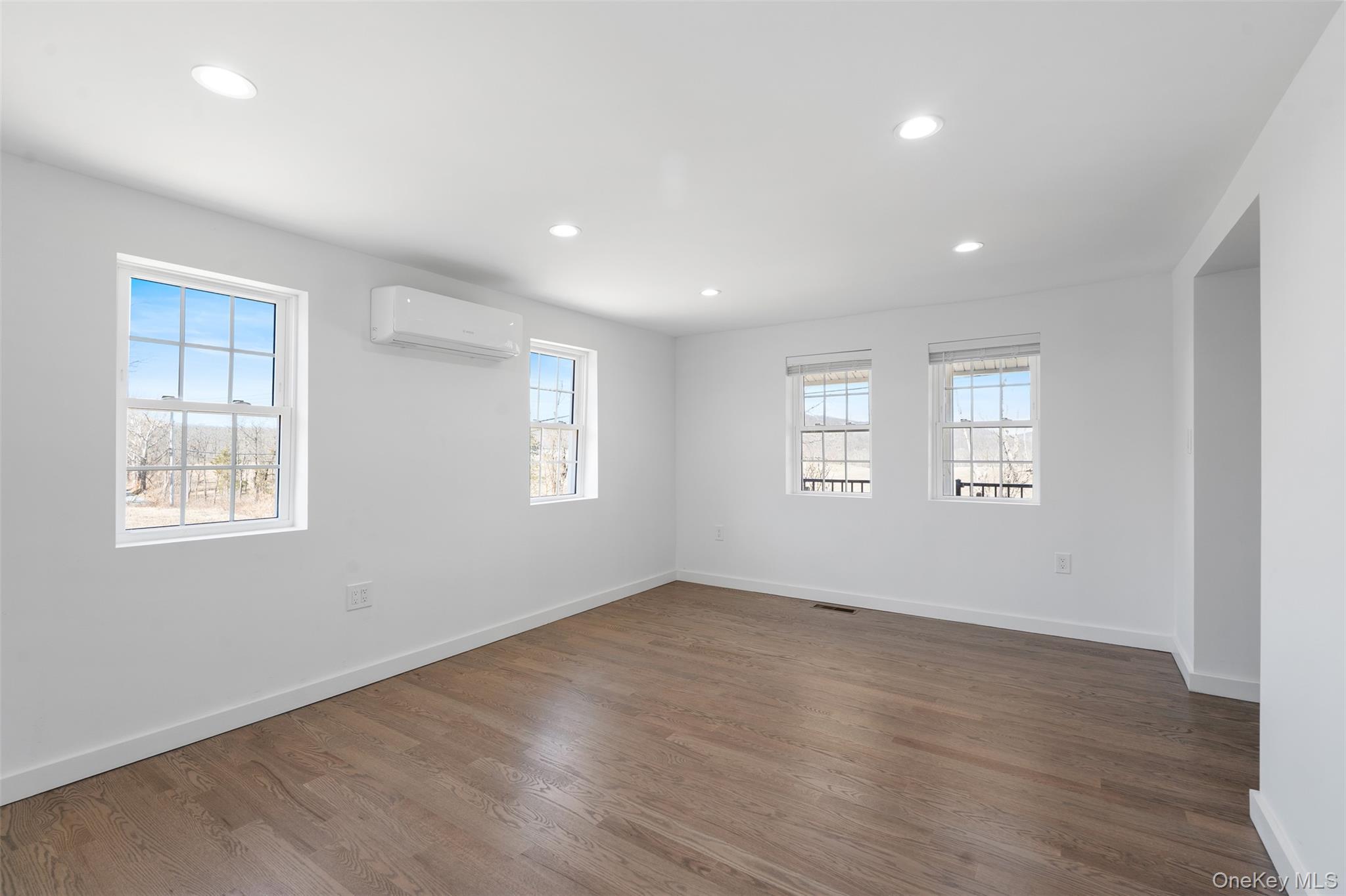 70 Barmore Road LaGrangeville, NY 12540 - Photo 15 of 47 Unfurnished room featuring a wall mounted air conditioner, healthy amount of natural light, recessed lighting, and wood finished floors