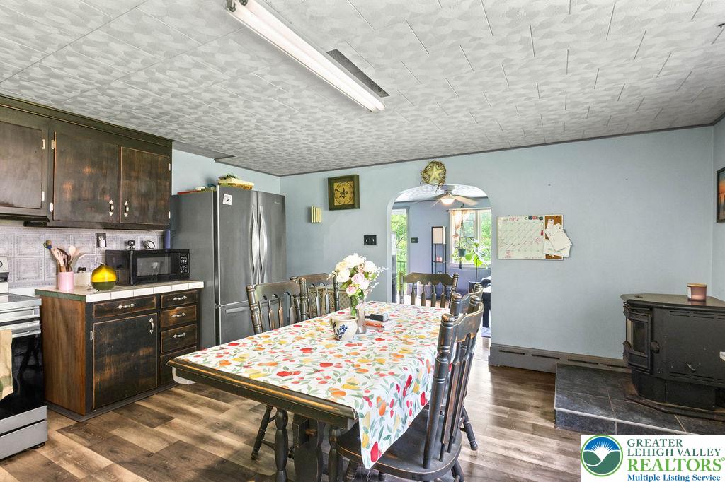1644 Moselem Spring Road Hamburg, PA 19526 - Photo 9 of 24 a kitchen with stainless steel appliances granite countertop a refrigerator a stove top oven a sink dishwasher and dining table with wooden floor