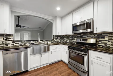 a kitchen with granite countertop a refrigerator and a stove top oven