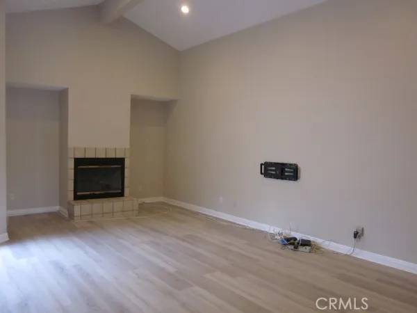an empty room with wooden floor and a fireplace