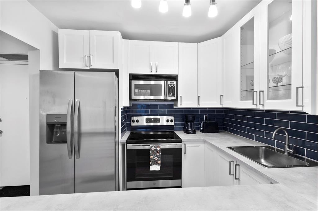 251 South Cypress Road, Unit 127 Pompano Beach, FL 33060 - Photo 3 of 29 a kitchen with a sink stove and refrigerator
