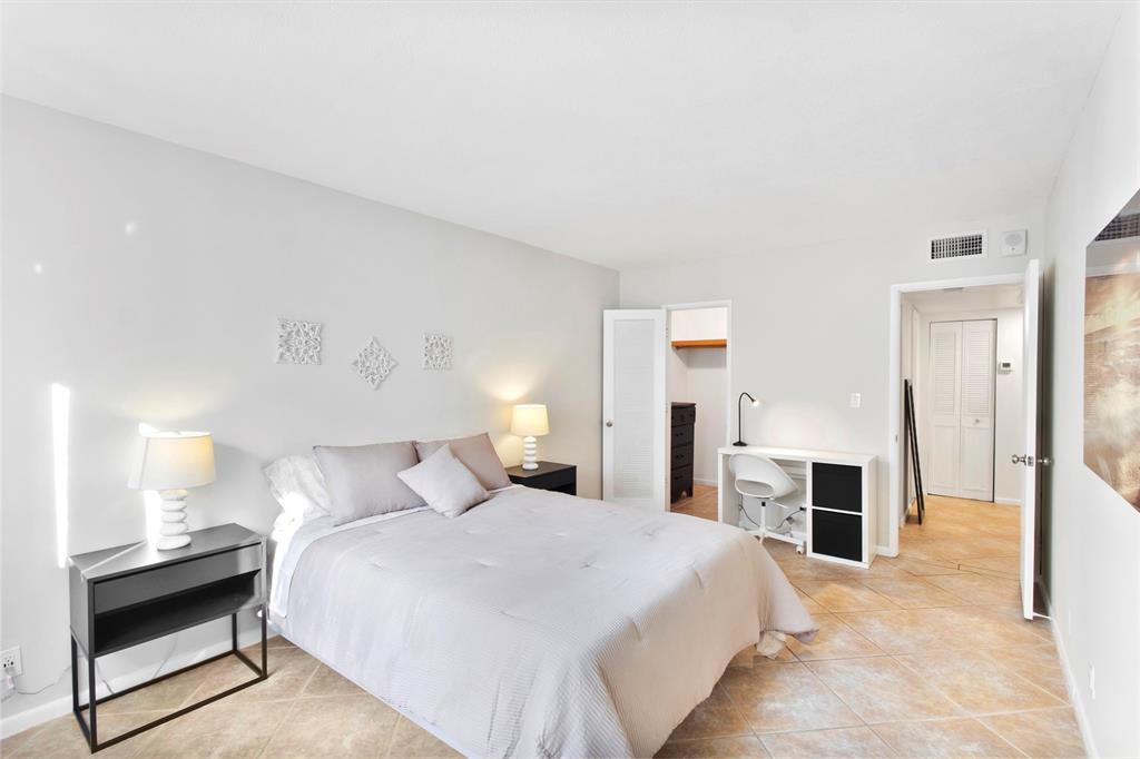 251 South Cypress Road, Unit 127 Pompano Beach, FL 33060 - Photo 8 of 29 a bedroom with a bed and a chandelier