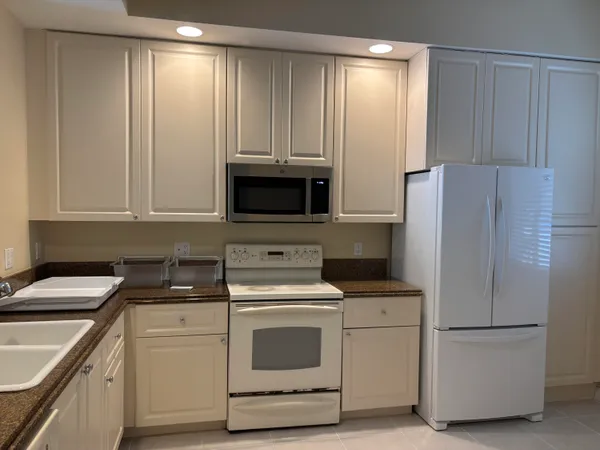 a kitchen with appliances a sink and cabinets
