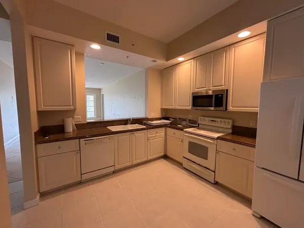 a large white kitchen with cabinets a sink and a stove