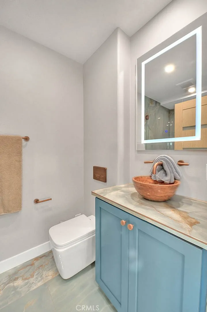 99 Surfside Avenue Surfside, CA 90743 - Photo 13 of 75 a bathroom with a granite countertop sink and a mirror
