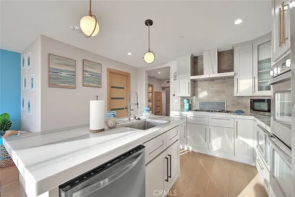 a kitchen with stainless steel appliances granite countertop a sink a stove and a wooden floors