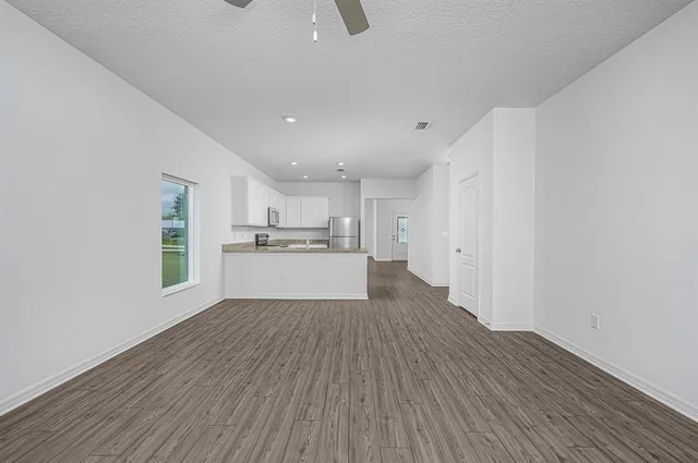 a view of a kitchen with wooden floor and windows