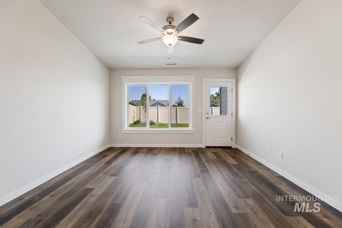 212 East Radiant Ridge Drive Meridian, ID 83642 - Photo 13 of 36 Spare room with ceiling fan, dark wood-style floors, and a textured ceiling