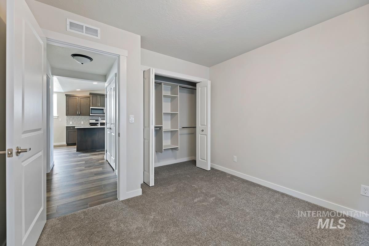 212 East Radiant Ridge Drive Meridian, ID 83642 - Photo 21 of 36 Unfurnished bedroom with dark carpet, a closet, and recessed lighting