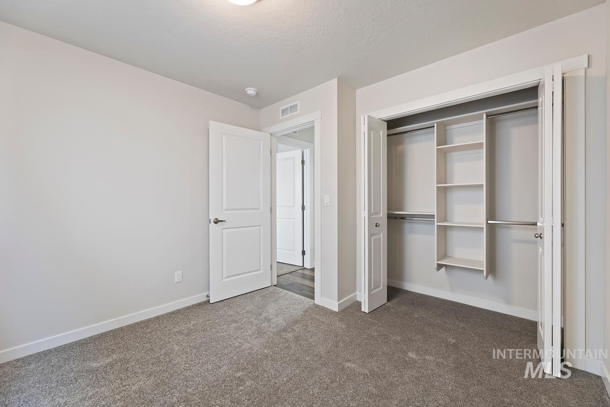 212 East Radiant Ridge Drive Meridian, ID 83642 - Photo 23 of 36 Unfurnished bedroom featuring dark carpet and a closet