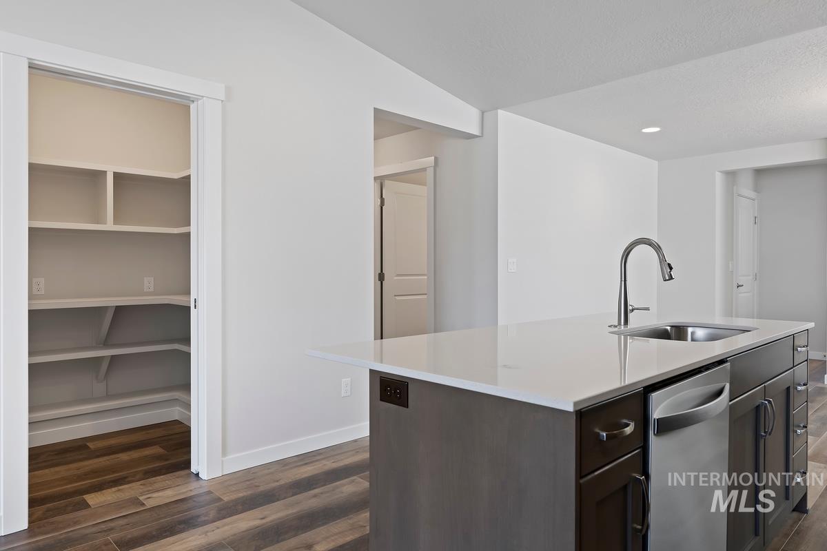 212 East Radiant Ridge Drive Meridian, ID 83642 - Photo 9 of 36 Kitchen featuring dark wood finish cabinetry, dark wood-style flooring, a kitchen island with sink, dishwasher, and recessed lighting
