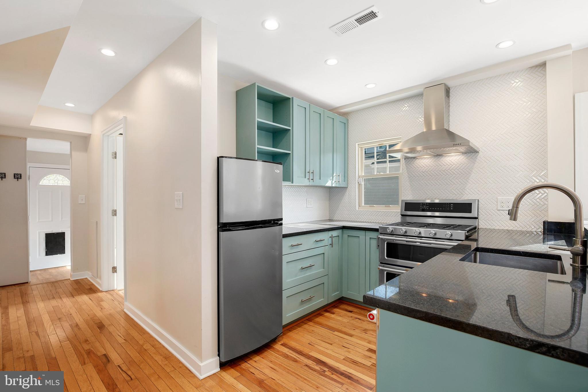 304 Marshall Street Gaithersburg, MD 20877 - Photo 13 of 38 a kitchen with kitchen island a counter top space a sink stainless steel appliances and cabinets