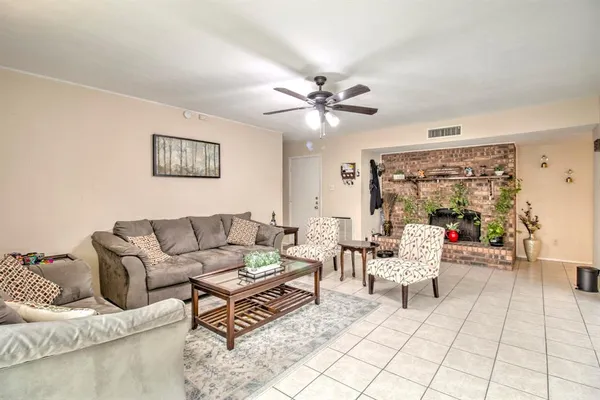 a living room with furniture and a ceiling fan