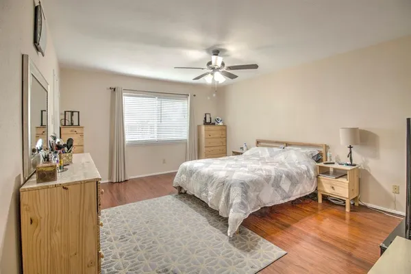 a bedroom with a bed flat screen tv closet and a large window
