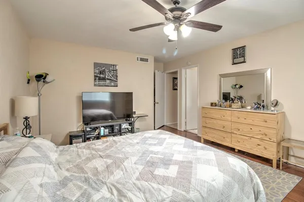 a bedroom with a bed and a flat tv screen on dresser