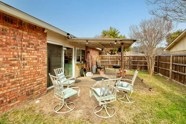 a view of a patio with table and chairs and potted plants