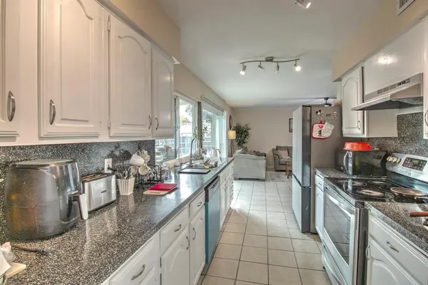 a kitchen with stainless steel appliances granite countertop a sink stove and cabinets