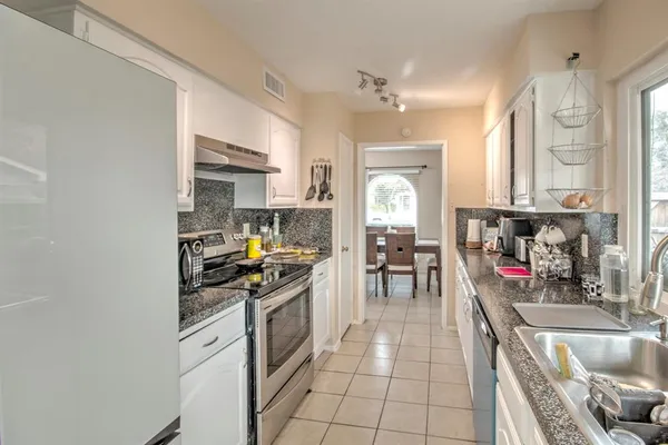 a kitchen with stainless steel appliances granite countertop a sink and a stove