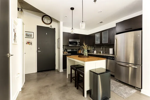 a kitchen with refrigerator a microwave and cabinets