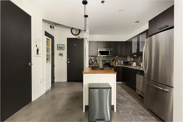 a kitchen with stainless steel appliances a refrigerator sink and microwave