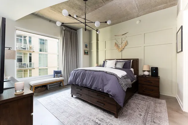 a spacious bedroom with a bed and wooden floor