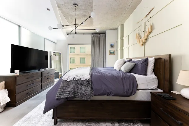 a bedroom with a bed and flat screen tv