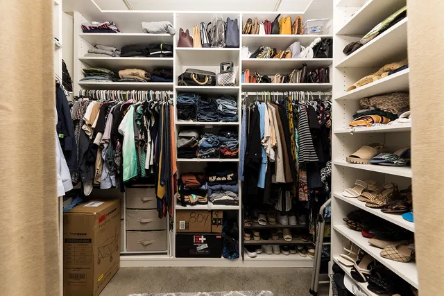 a view of walk in closet with clothes and shoes