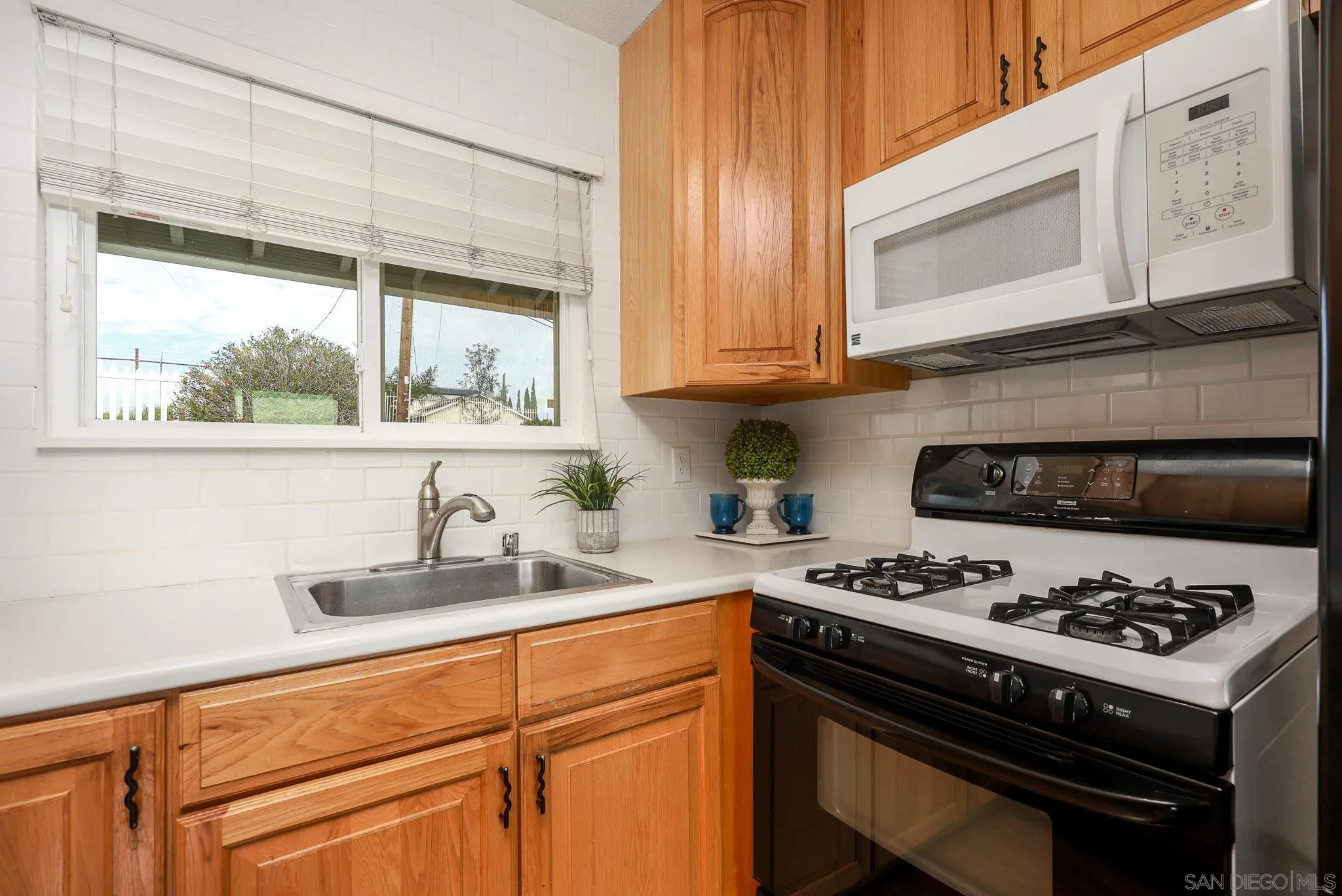 11739 Walnut Road Lakeside, CA 92040 - Photo 12 of 32 a kitchen with stainless steel appliances a stove a sink dishwasher and cabinets with wooden floor