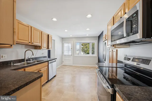a kitchen with stainless steel appliances granite countertop a sink stove and cabinets