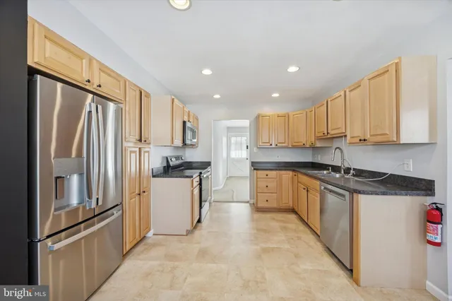 a kitchen with stainless steel appliances granite countertop a refrigerator sink and cabinets