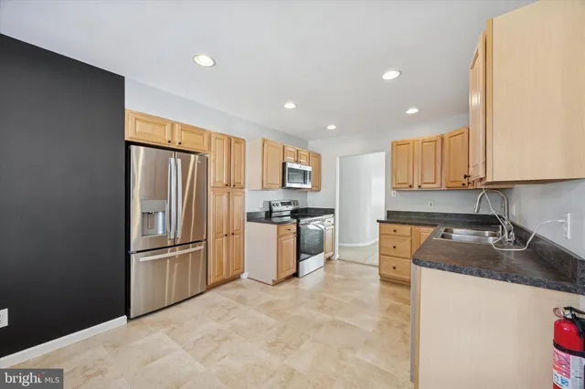 a kitchen with granite countertop a refrigerator and a sink