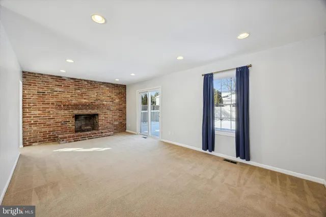 a view of an empty room with a fireplace and a window