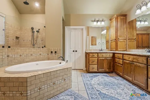 a bathroom with a tub sink and mirror