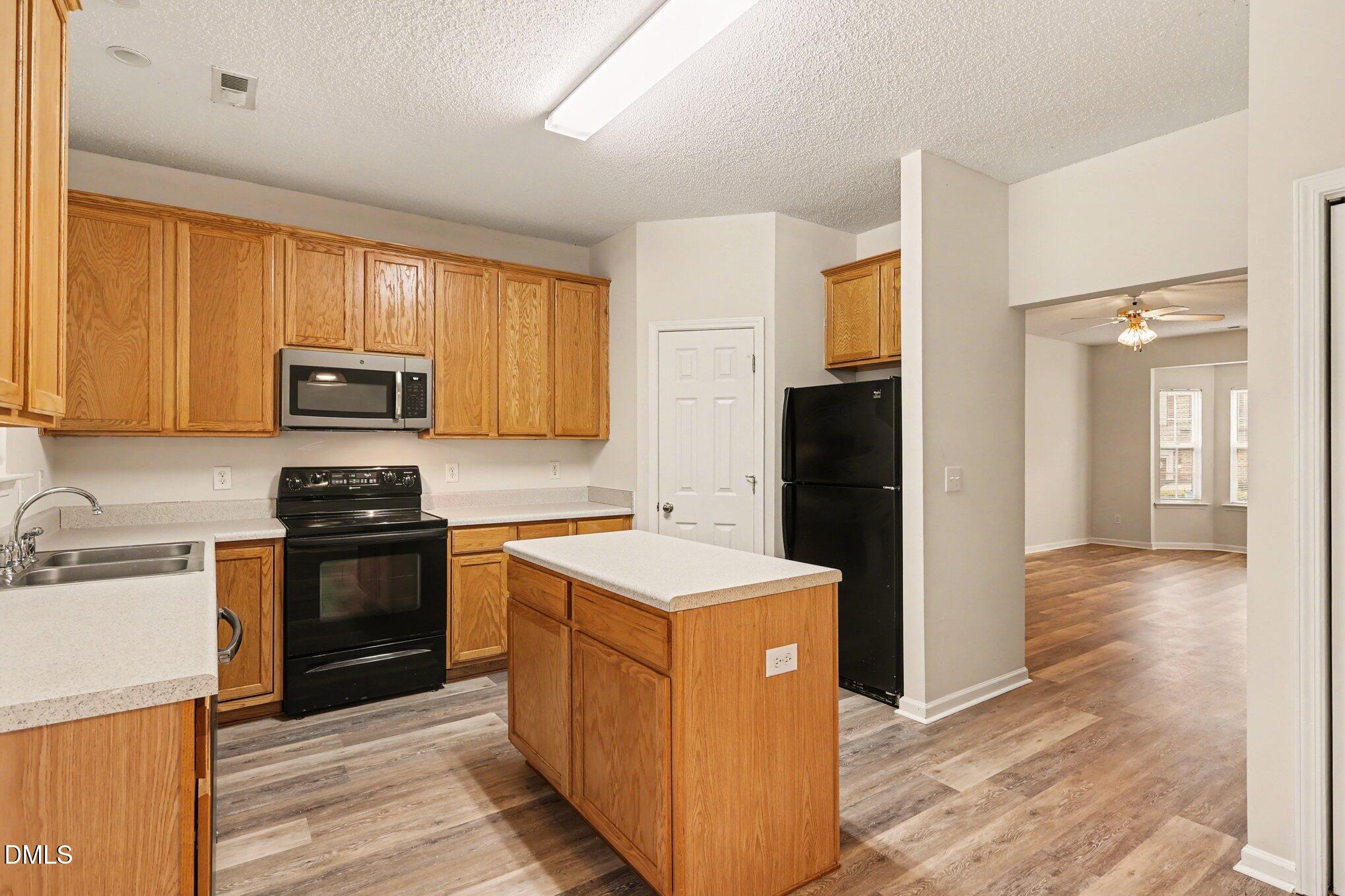 10947 Pendragon Place Raleigh, NC 27614 - Photo 9 of 21 a kitchen with a stove top oven and refrigerator