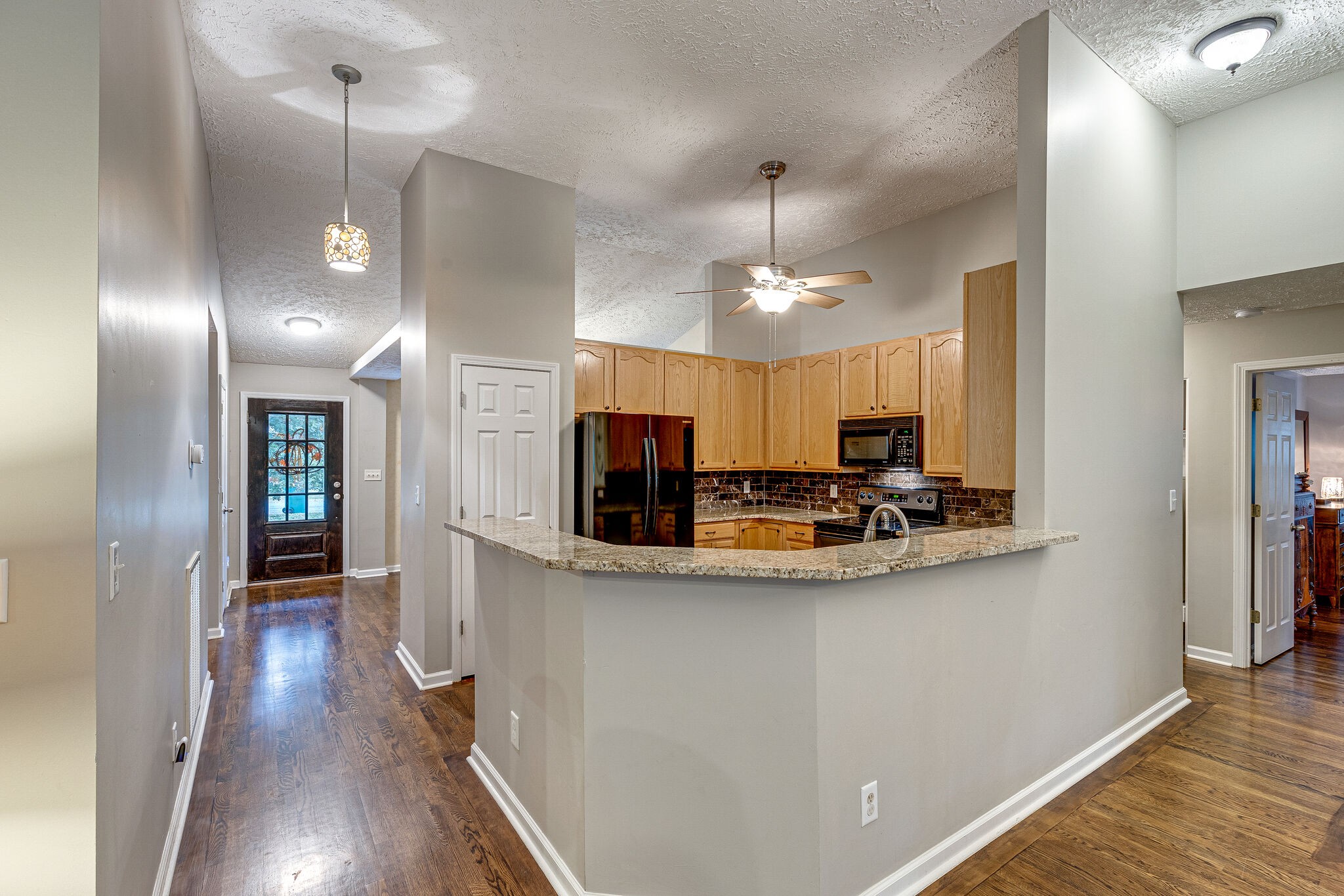 1882 O'Reilly Circle Spring Hill, TN 37174 - Photo 6 of 17 a view of a kitchen with kitchen island granite countertop wooden floor and stainless steel appliances