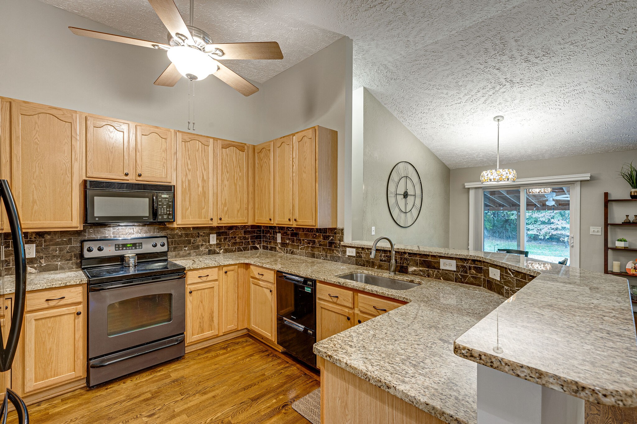 1882 O'Reilly Circle Spring Hill, TN 37174 - Photo 7 of 17 a kitchen with granite countertop a sink a stove top oven a clock and cabinets