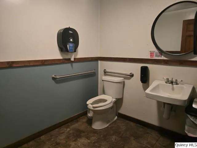 a bathroom with a toilet sink and mirror