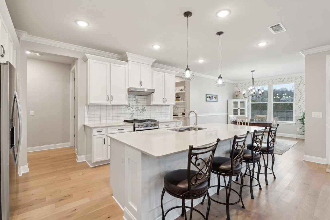 709 Mercer Road Mount Juliet, TN 37122 - Photo 7 of 40 a kitchen with stainless steel appliances kitchen island granite countertop a table chairs stove and white cabinets