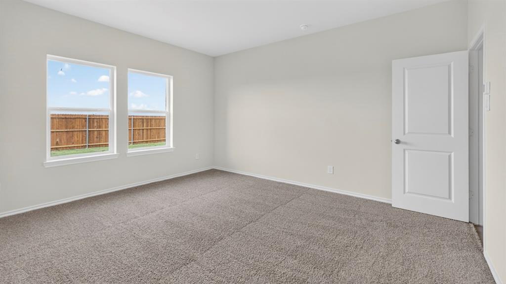 1683 Mantle Road Crandall, TX 75114 - Photo 19 of 31 Bright interior room featuring neutral wall paint, two large windows, gray carpet flooring, white baseboards, and a white two-panel door
