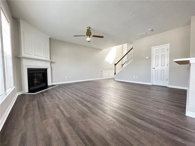 a view of empty room with wooden floor and fireplace