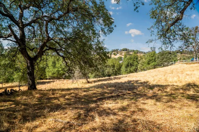 a view of a white building with a yard and outside space