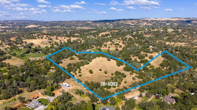 an aerial view of a house with a yard and lake view