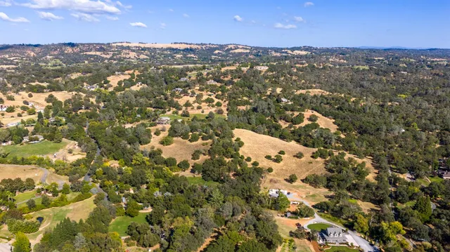 an aerial view of house with yard and mountain view in back