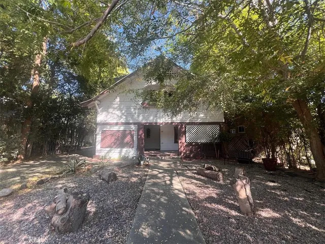 a view of a house with a yard and tree