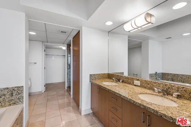 a bathroom with a granite countertop sink a toilet and shower