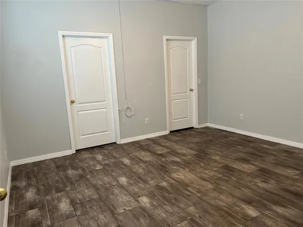 an empty room with wooden floor and closet