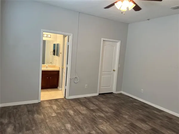 an empty room with closet and chandelier fan