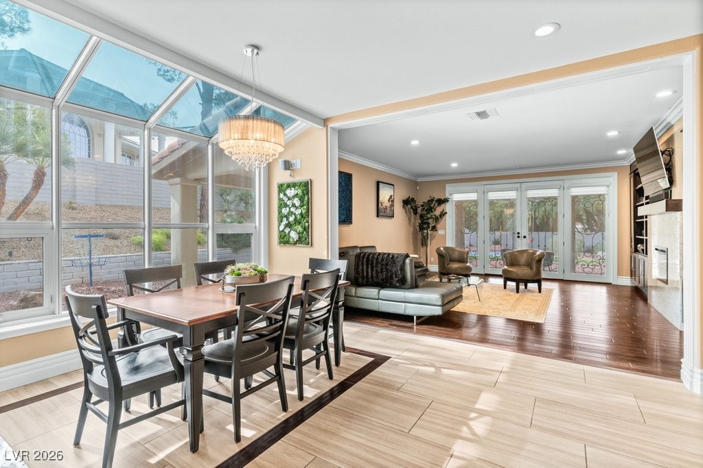 7 Larkside Court Henderson, NV 89014 - Photo 16 of 70 Dining room with wood finish floors, crown molding, a sunroom, recessed lighting, and a fireplace