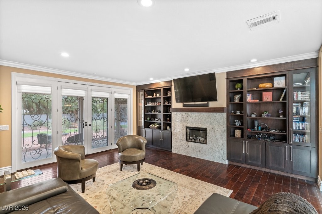 7 Larkside Court Henderson, NV 89014 - Photo 20 of 70 Living area featuring built in features, dark wood-style floors, ornamental molding, recessed lighting, and french doors
